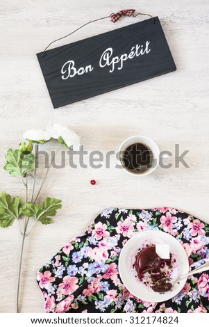 Cup of coffee with sweet dessert and beautiful flower
