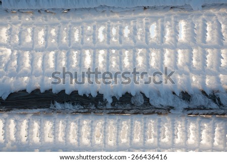A close up of a fence with snow frozen