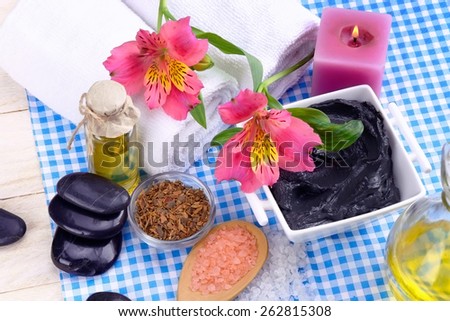 therapeutic dead sea mud stones for Spa treatments and sea salt and oak bark flowers massage oil and a towel