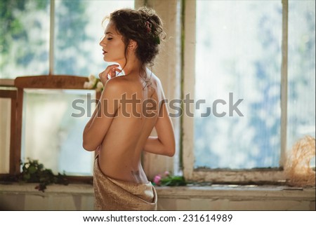 Portrait of a sensual kinky girl with closed eyes bare backed in beige