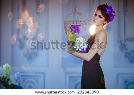 very beautiful brunette woman with flowers in her hair holding cell in the hands of