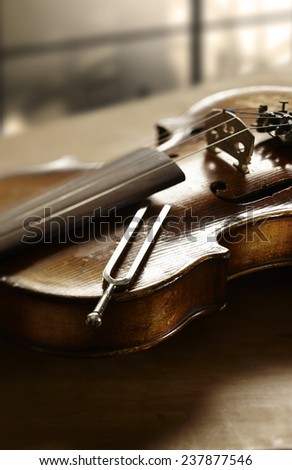 Still life photography of violin and tuning fork