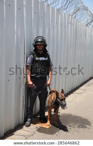 ATLIT, ISRAEL - JUNE 03, 2015: Police officer dog trainer at Carmel Prison holds his obedient working watch dog for law enforcement, crime fighting, anti terrorism and security