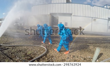 HAIFA, ISRAEL - JUNE 30, 2015: Firefighters from Northern Israel with protective gear during simulation drill walk to seal a leak of Bromine chemical in a container car of train.