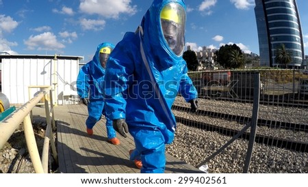 HAIFA, ISRAEL - JUNE 30, 2015: Firefighters from Northern Israel with protective gear approach disaster area during simulation drill of leak of Bromine chemical in a container car of train