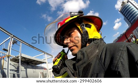 HAIFA, ISRAEL - JUNE 30, 2015: Firefighter from Northern Israel with protective gear talks with walky talky during simulation drill of leak of Bromine chemical in a container car of train