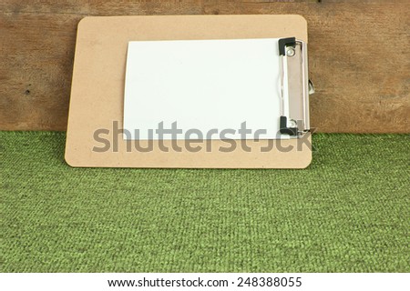 Memo Pad brown corrugated pattern on green carpet.
