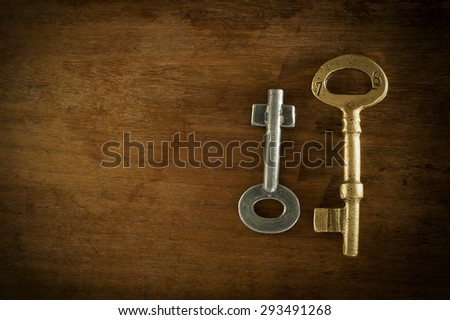 Old two keys placed on a wooden floor low key light