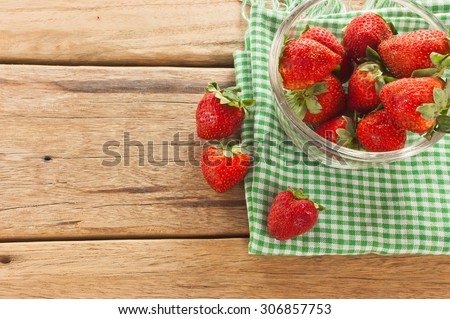 Strawberry berries on a wooden table. And green table cloths