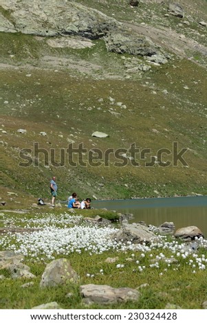 ORCIERES, FRANCE- AUGUST 6, 2006: Family enjoying a sunny day at a mountain lake. Estaris lake in Alps, France.