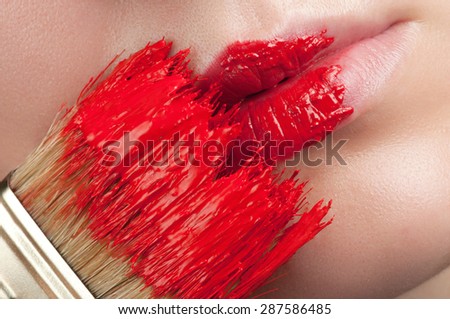 Red lips with paint from the brush.