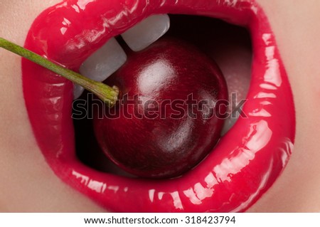 Lip gloss painted red with cherries in the mouth.