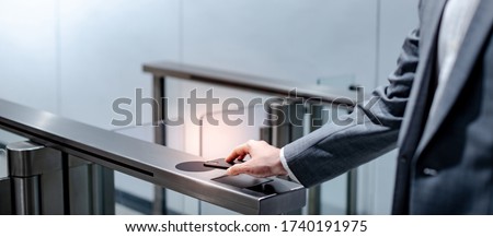Businessman hand with business wear using smartphone to open automatic gate machine in office building. Working routine concept Foto d'archivio © 