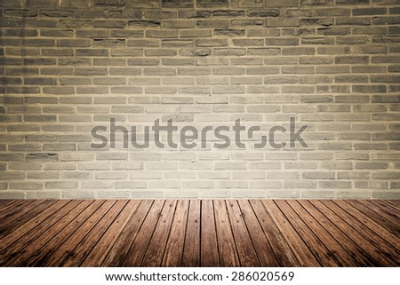 Old interior room with abstract dark beige brick wall pattern and brown wood floor