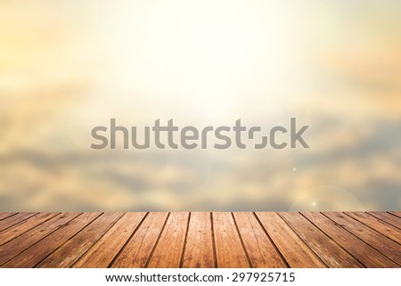 Brown wooden floor with abstract blurred background in sunset sky tone color and sunlight on top. use for backdrop or web design