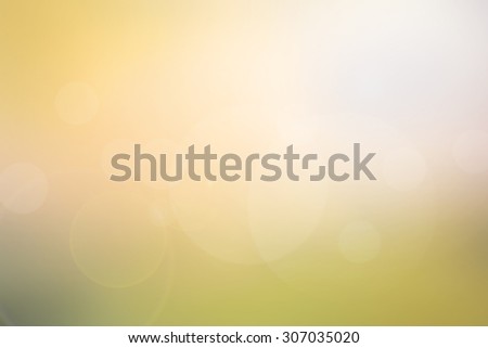 Abstract light yellow-green blurred background in warm tone with bright sunlight, flare and bokeh effect, use for backdrop or design element in tropical summer concept