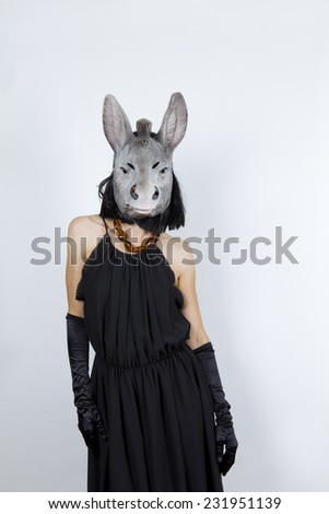 Woman wearing a donkey mask with an evening dress and evening gloves