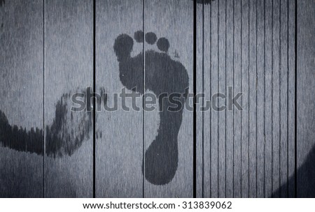 Foot prints from wet feet on weathered wooden step