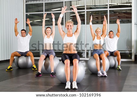 group of fitness people exercise on gymnastic balls in a gym