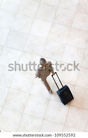 overhead view of young businesswoman walking at airport