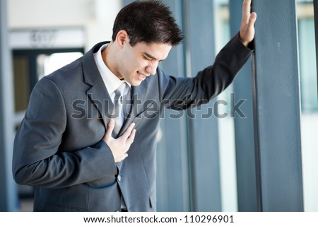 young businessman having heart attack or chest pain