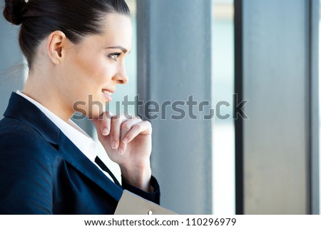 beautiful young businesswoman looking outside window