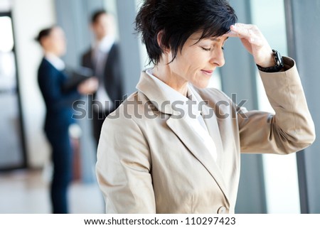 middle aged businesswoman having headache in office