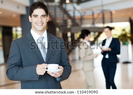 handsome businessman having coffee break in office