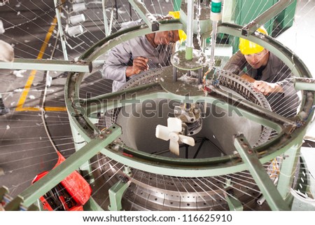 two textile factory technician repairing weaving loom