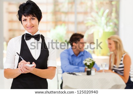elegant mature waitress working in restaurant