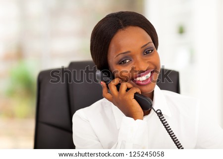 pretty female african office worker talking on phone