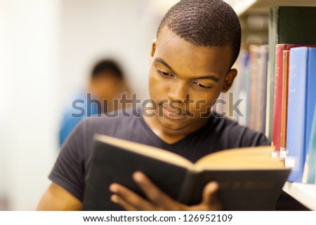 male african university student reading in library