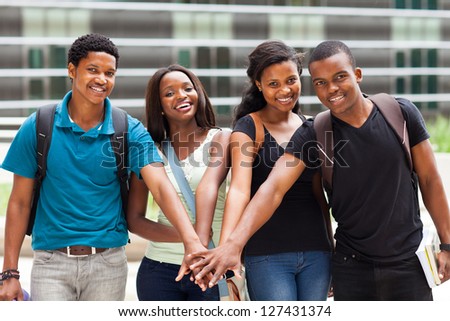group of african college students putting hands together