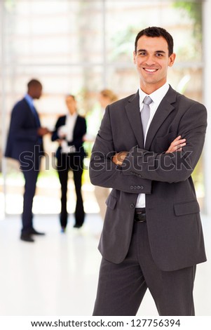 handsome businessman arms folded portrait in office