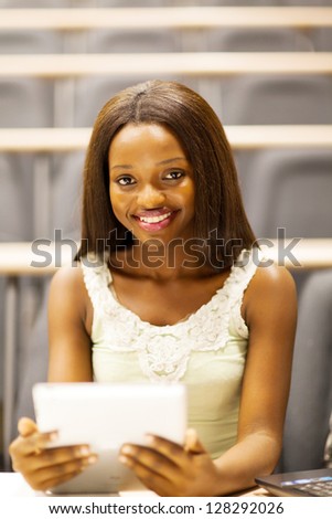 female african college student using tablet computer in lecture room