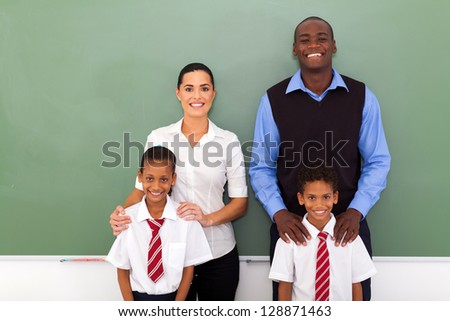 group of elementary school teachers and students in front of chalkboard