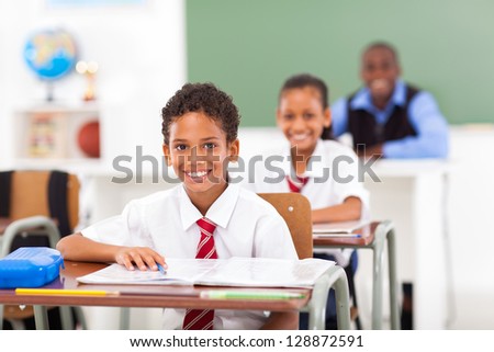 primary students and teacher sitting in classroom