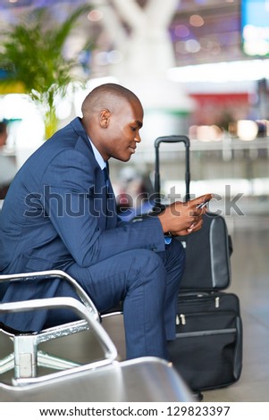 african businessman using cell phone at airport