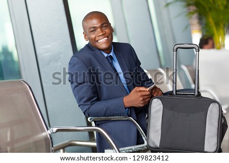 happy african american businessman waiting by airport