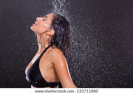 sexy girl posing in water splashes over black background