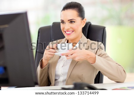 caucasian business woman having tea in front of computer