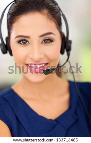 Closeup portrait of a happy young call centre employee smiling with a headset