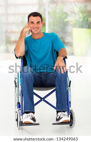 happy disabled man sitting on wheelchair at home