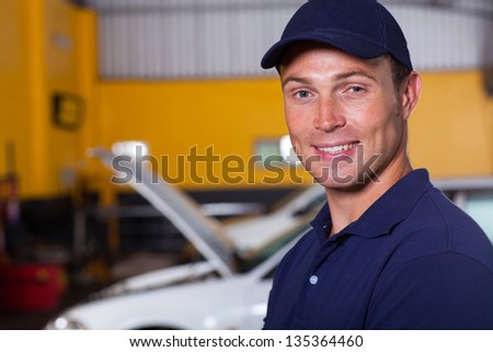 portrait of trustworthy auto mechanic inside workshop