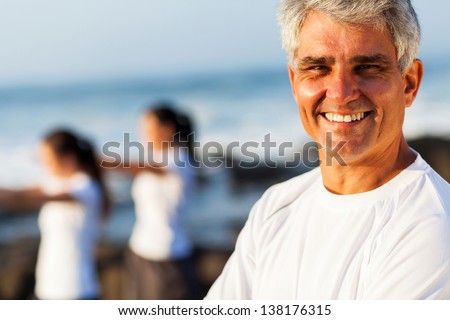 smiling handsome active senior man posing at the beach with family