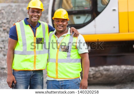 african industrial co-workers portrait in front of machine