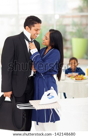 loving wife helping husband with his tie before he going to work