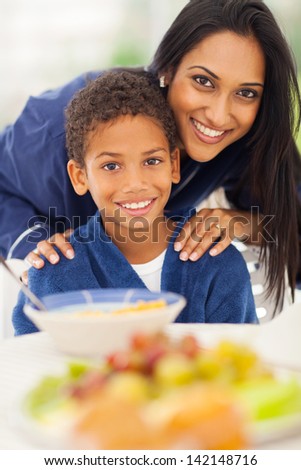 close up portrait of indian mother and son at breakfast table