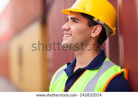optimistic young harbor worker in container yard