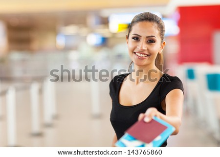 beautiful businesswoman handing over passport and air ticket at airport check in counter